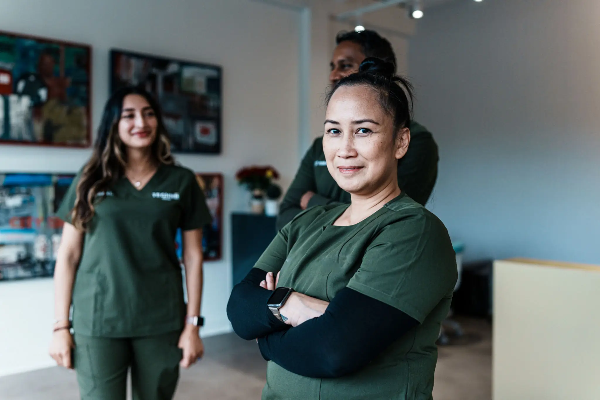 Smiling healthcare professionals in green scrubs